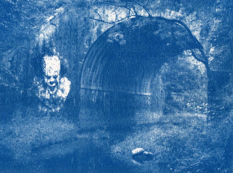 Tunnel en pierre avec la rivière qui passe en dessous et de la végétation tout autour. Ajout par collage du clown Pennywise sur un mur comme s'il était incrusté.
