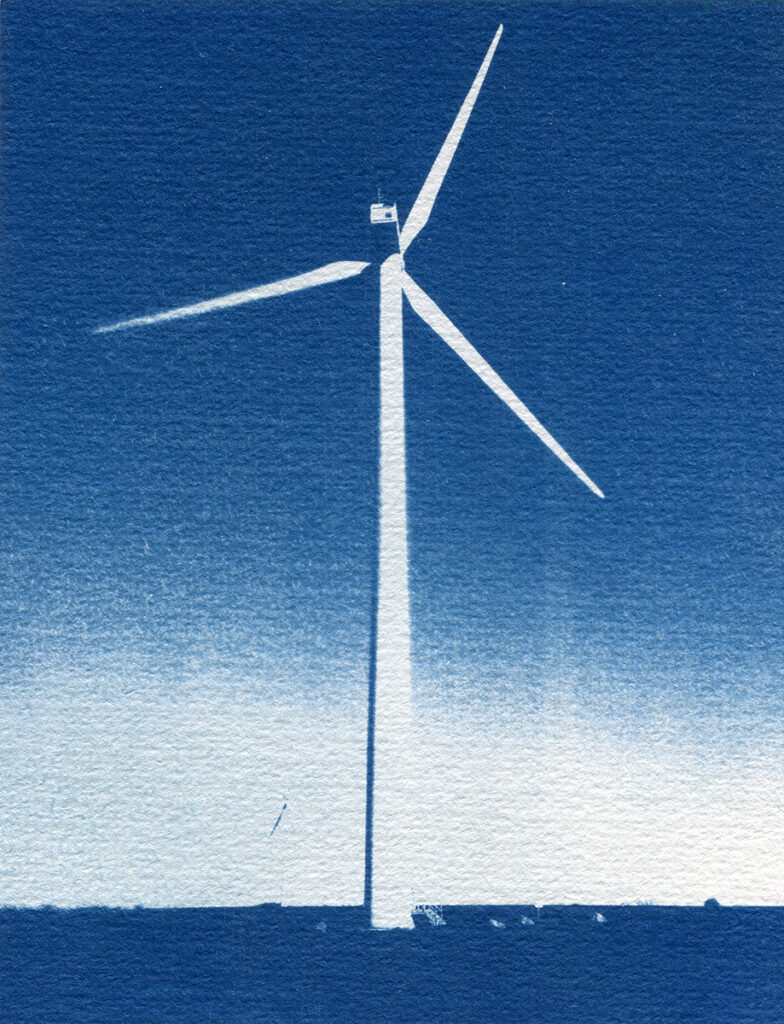 Éolienne dans un champ avec un ciel dégradé de bleus en arrière plan.