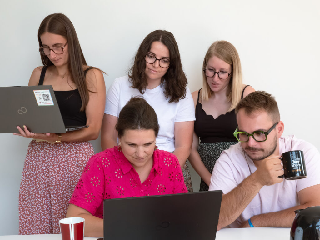 Un groupe d'employés de bureau affairés devant des ordinateurs.
